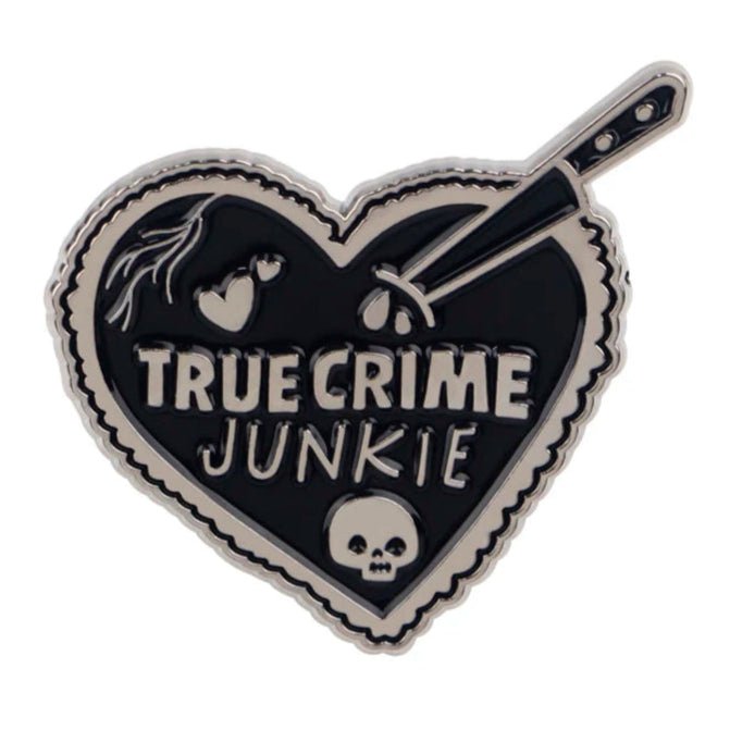 The Kiss Me Later heart-shaped coffin badge says TRUE CRIME JUNKIE and features a skull, dripping knife, and heart details in bold black and silver.