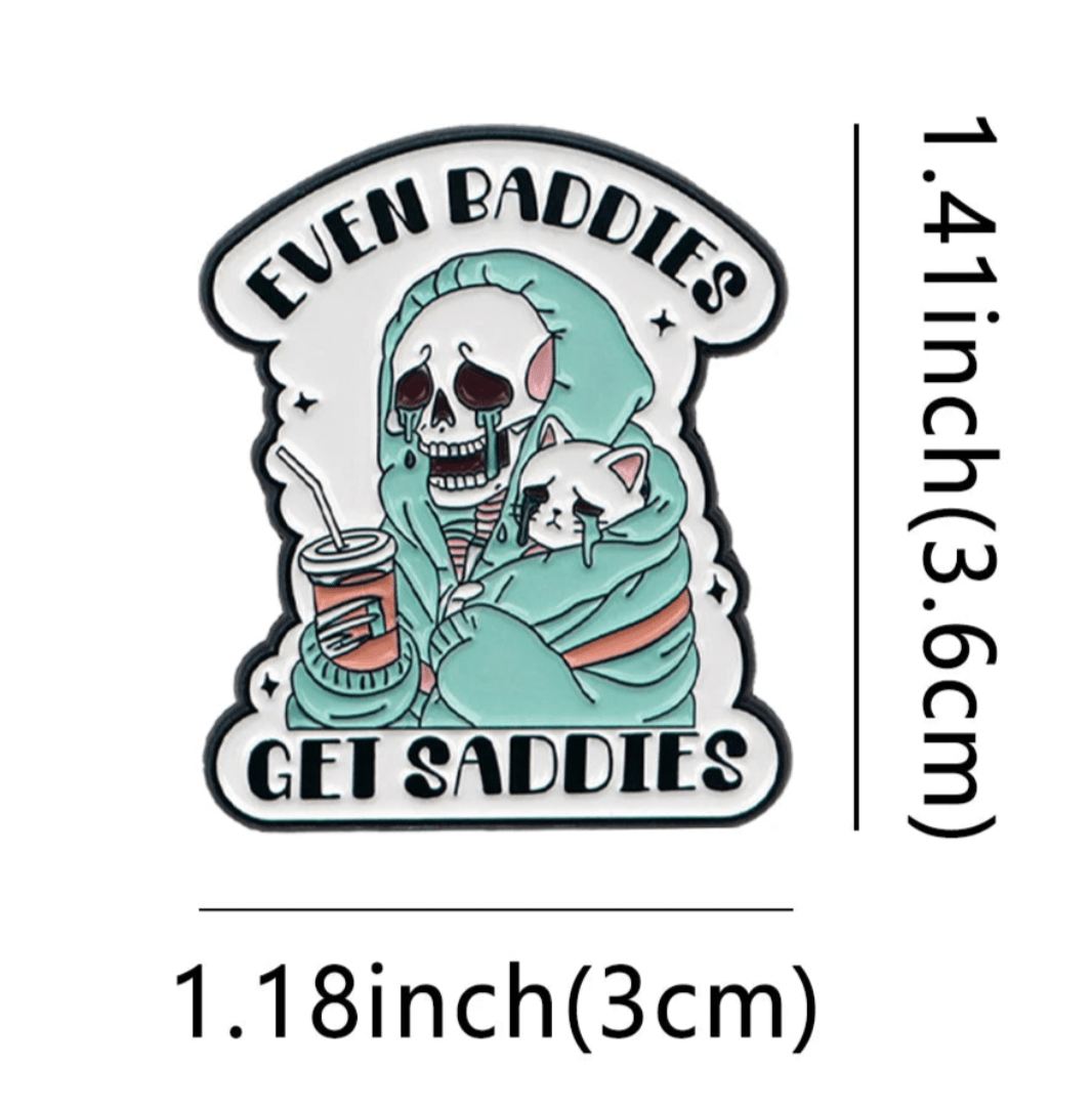 Show off your love for true crime with this Kiss Me Later cat pin featuring a skeleton in a green hoodie holding a drink and a sad white cat, plus the text EVEN BADDIES GET SADDIES. Measures 1.41 tall x 1.18 wide.